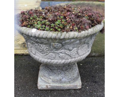 A cast garden planter on stand containing succulents