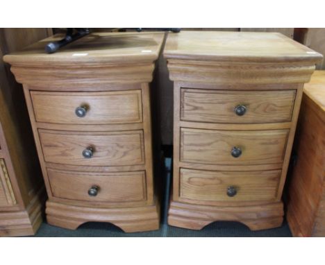 A pair of modern light oak bow fronted three drawer chests