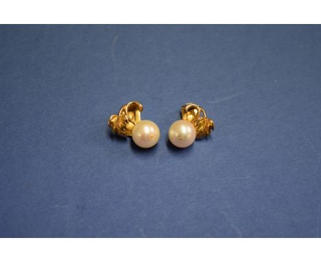 A pair of 9ct gold clip on pearl ear studs, having leaf decoration.