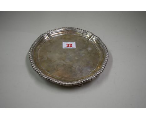 A George III silver salver, by Thomas Hannam & Richard Mills, London 1763, having gadrooned border and standing on three scro