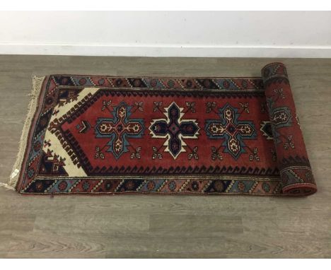 PERSIAN RUNNER,with central medallions and border on a red ground, 295cm x 82cm