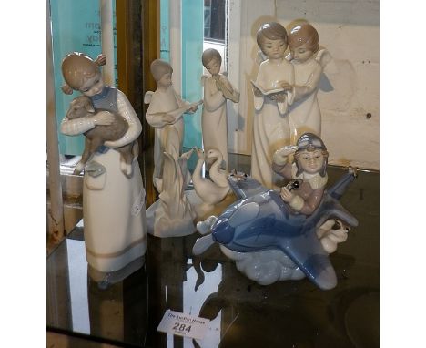 Lladro figure of a boy in a plane (No5697), a Lladro girl with lamb, and four various Nao figurines