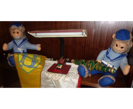 Mid-century fluorescent desk lamp, two soft toy monkeys and three banners