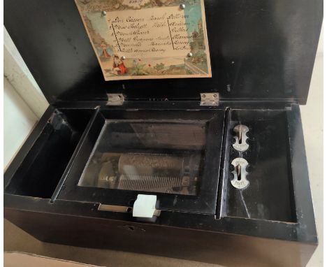 A 19th century cylinder music box playing 6 airs, walnut case with transfer motif.&nbsp;Comb seems in good order, however it 
