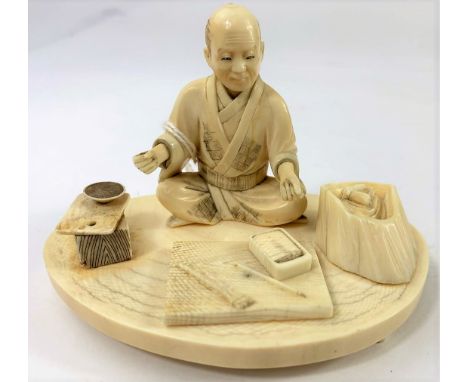 A Japanese carved ivory Okimono figure of a seated artisan, 10.5cm.&nbsp;&nbsp;Natural cracking to base, item missing from ha