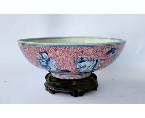 A Chinese ceramic bowl decorated with blue and white figures of Sages and a red painted wave pattern, with seal mark to base 