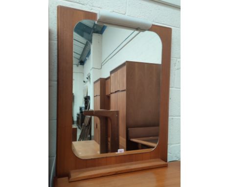 A mid century teak backed mirror with under-shelf 