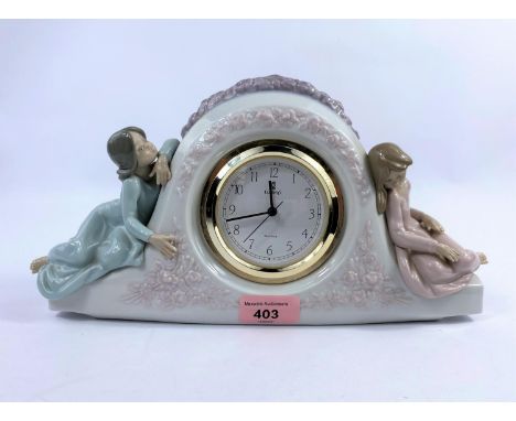 A Lladro porcelain clock, numbered 5776, with quartz movement &amp; two young girls sat either side, length 31cm.&nbsp;&nbsp;