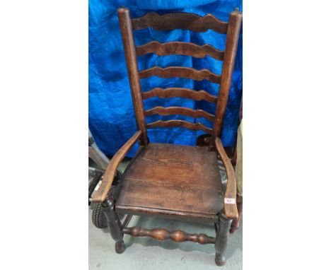 A Country made oak ladder back low seat and arm chair with a solid seat. 