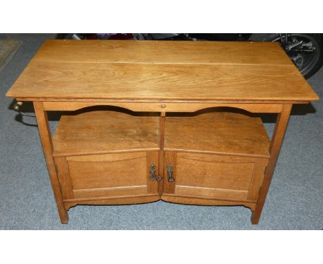 An Edwardian oak table, the rectangular top 109 x 52 cm over open shelf above twin canted cupboards. There is a towel rail to