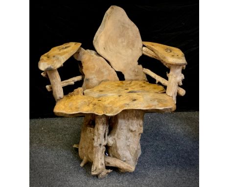 A tree root, naturalistic garden chair, the base of interlocking teak tree roots, with a seat of well figured tree trunk cros