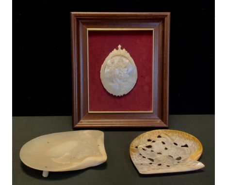 A Mother of pearl carved shell inscribed Assunzione DIMV, framed; pierced mother of pearl shell carved with an elephant, plai