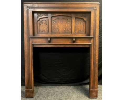 An early 20th century large oak fire surround/ Chimney-piece, recessed top with carved panels, and shelf, 177cm high x 136cm 