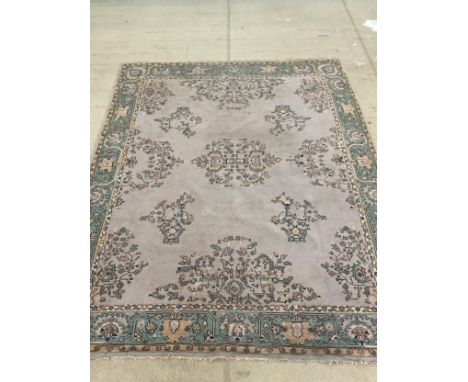 A large floral rug/carpet in tones of turquoise, yellow and cream, approx. 350cm x 280cm. 
