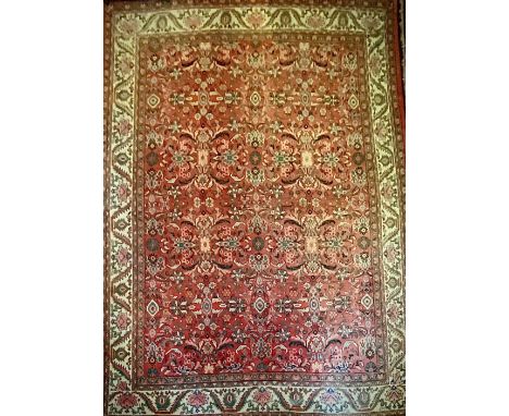 A large Iranian/Persian hand knotted mahal carpet in tones of blue, green, ochre and red on a predominantly cream ground, tri
