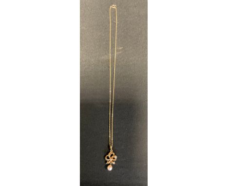 A 9ct gold ribbon tied pendant with pearl dropper 