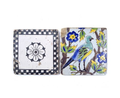 AN ISLAMIC POLYCHROME POTTERY SQUARE TILE decorated a bird on a branch, 21cm; and another black and white tile with central r