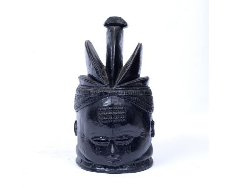 A MENDE 'BUNDU' HELMET MASK, SIERRA LEONE, carved wood with a high gloss ebonised finish, high three sectioned coiffure and s