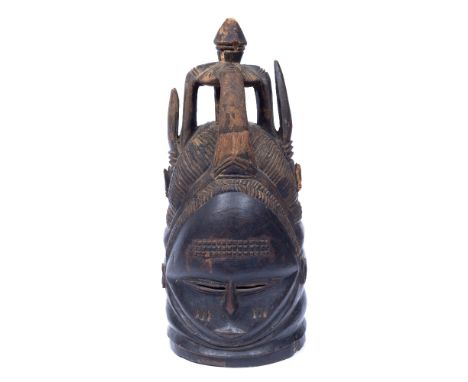 A MENDE 'BUNDU' HELMET MASK, SIERRA LEONE, carved wood with a crown shaped headdress, 42cm high Provenance: from the estate o