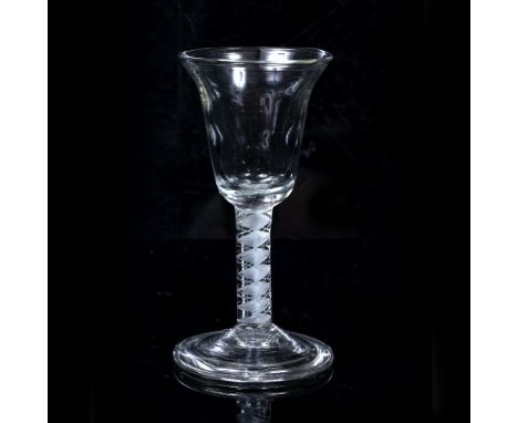 AN 18TH CENTURY WINE GLASS with bell shaped bowl, the stem opaque white corkscrew with a pair of spiral white threads and a f