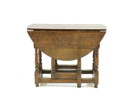 A 17th century and later circular oak gate leg table, with end drawer on baluster columns. 90cm long, 111cm wide (open) 67cm 