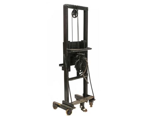 An industrial cast iron easel, 20th century, American, with a winding rise and fall mechanism, originally used as a hoist, 51