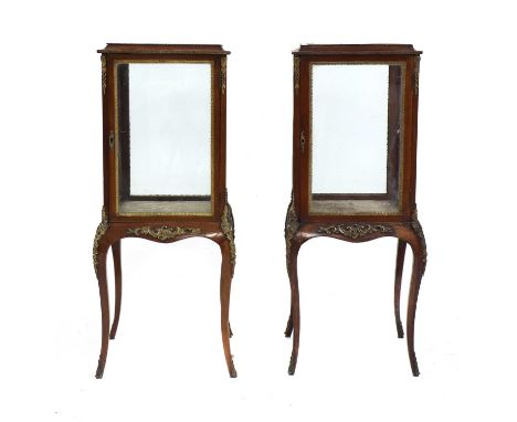 A pair of late Victorian mahogany bijouterie cabinets, with ormolu mounts, raised on cabriole legs, each side with a clear gl