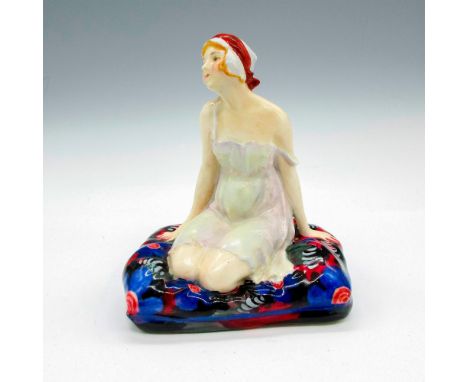 Glossy Art Deco figural dressed in light colored negligee, seated on blue, black and red colored cushion. Royal Doulton backs