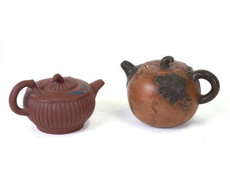 A Chinese Yixing teapot and cover decorated with insects, 9cms high; together with another similar, 7cms high (2).