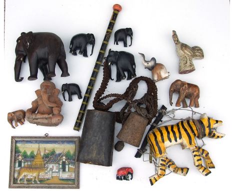 A quantity of tribal and Indian items to include a large cow bell, a carved wooden elephant and a tiger puppet.