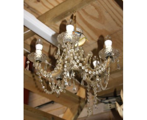 A five-arm brass ceiling light with crystal drops.