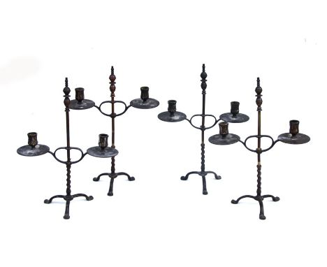 Four late 19th century patinated brass twin light candelabra in the Gothic Revival style, each with a rise and fall branch op