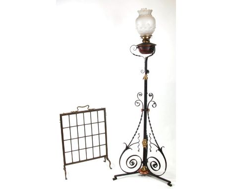 An Art Nouveau wrought iron telescopic oil standard lamp; together with a brass fire screen (2).