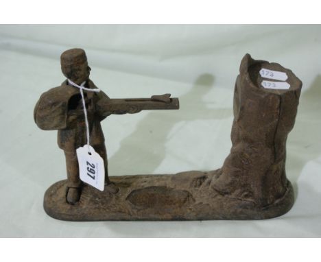 An American Cast Metal Novelty Money Bank In The Form Of A Soldier Shooting At A Tree Trunk, Traces Of Original Colour