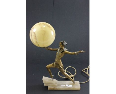 Art Deco lamp depicting a female in fanciful pose holding the glass globe lamp shade and on an Onyx base