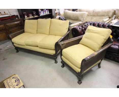 An early 20th century  mahogany bergere sofa with profusely carved stretcher raised on ball and claw feet together with match