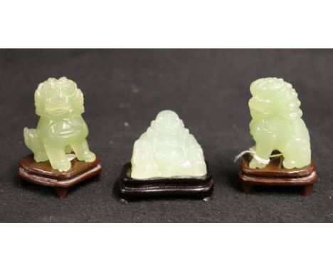 Pair of 20th century green jade lions and stands, 6.5cm and a similiar figure of Pu Tai, 4cm (3)