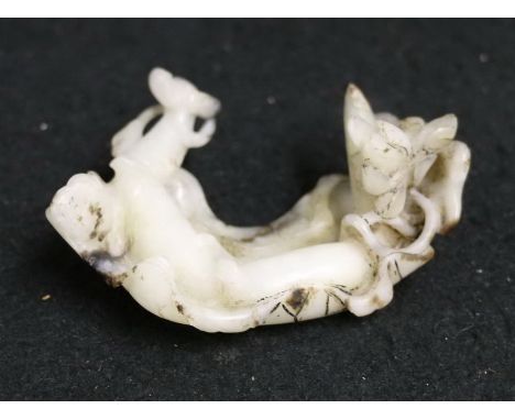 Chinese early 20th century carving in a black and mottled white / grey jade depicting a lily pad and lotus root with lily flo