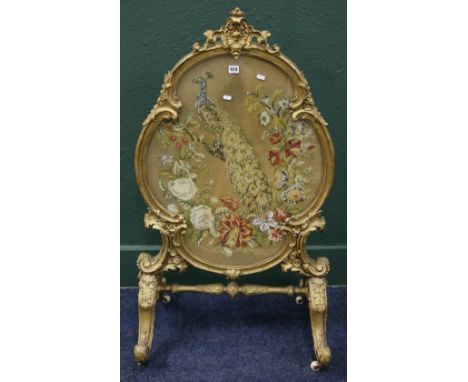Victorian gilt gesso oval firescreen with beadwork and wool peacock tapestry on scrolling cabriole supports, 118cm high x 66c