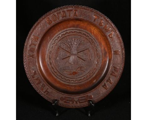 Late 19th century carved wooden circular Russian plaque with carved central plaque depicting a wheatsheaf and plough, 30cm