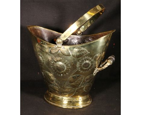 Late Victorian Arts and Crafts repousse brass coal helmet, with sunflowers in relief, the base stamped with indistinct makers