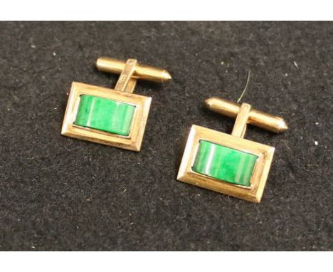 Pair of Astor 14k gold mounted jade cufflinks of rectangular form with collet set dome topped mottled green jade