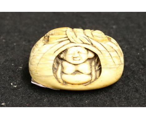 Japanese ivory netsuke, carved as Pu Tai wrapped in a linen bundle. Meiji, 4cm