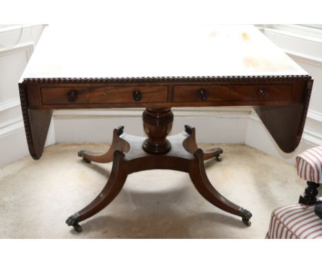 Victorian mahogany sofa table with bobbin moulded edge, on urn shaped column, with reeded brass capped legs and brass castors