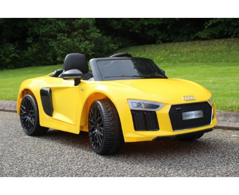 An Audi R8 Spyder Ride On Car - The rechargeable 12v car in yellow is licensed by Audi, and featuring Audi badges, opening do