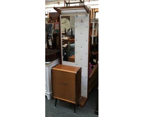 A mid century hall stand with long mirror and coat hooks, set onto a button upholstered board, with hanging rail above, and u
