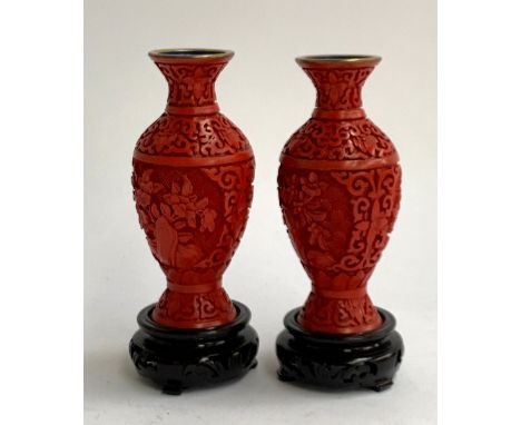 A pair of Chinese cinnabar lacquer vases brass vases, intricately carved foliate design, blue enamel interior and base, on ca