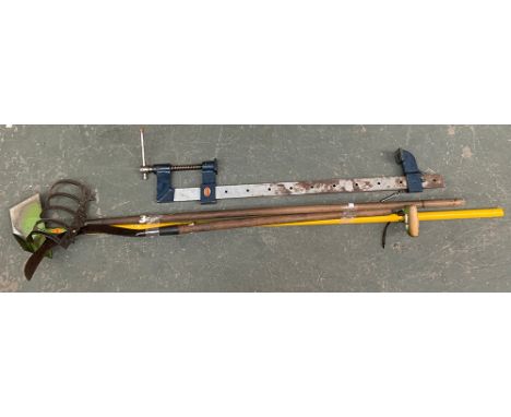 A very large metal sash clamp, by Woden; together with a number of long handled tools 