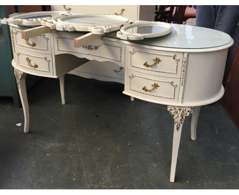 A 1960s style white and gilt kidney shaped dressing table, kneehole with single drawer, with adjustable oval three part mirro