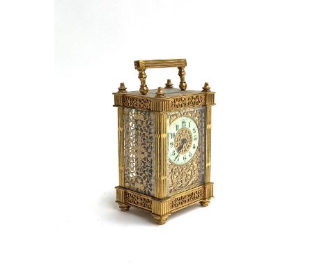 A gilt metal mantel clock, pierced scrolling sides, the enamel dial surrounded by scrolling decoration, 15cmH 